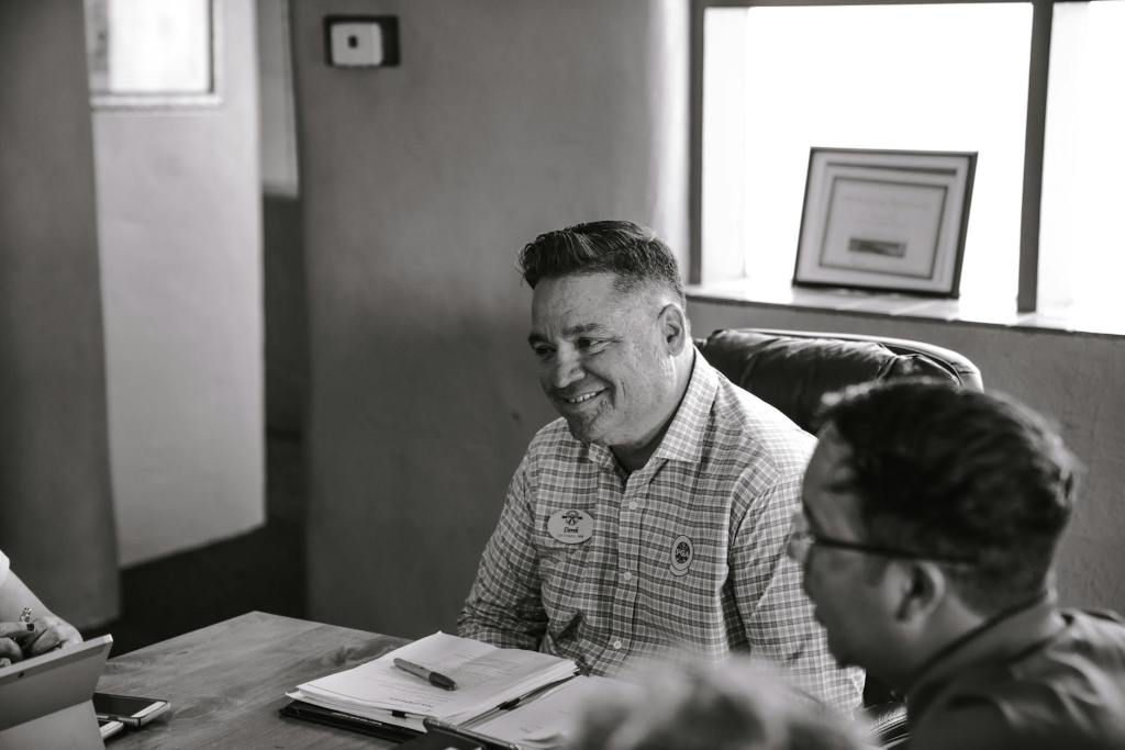 grayscale photo of man sitting on chair