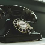 black rotary telephone on white surface