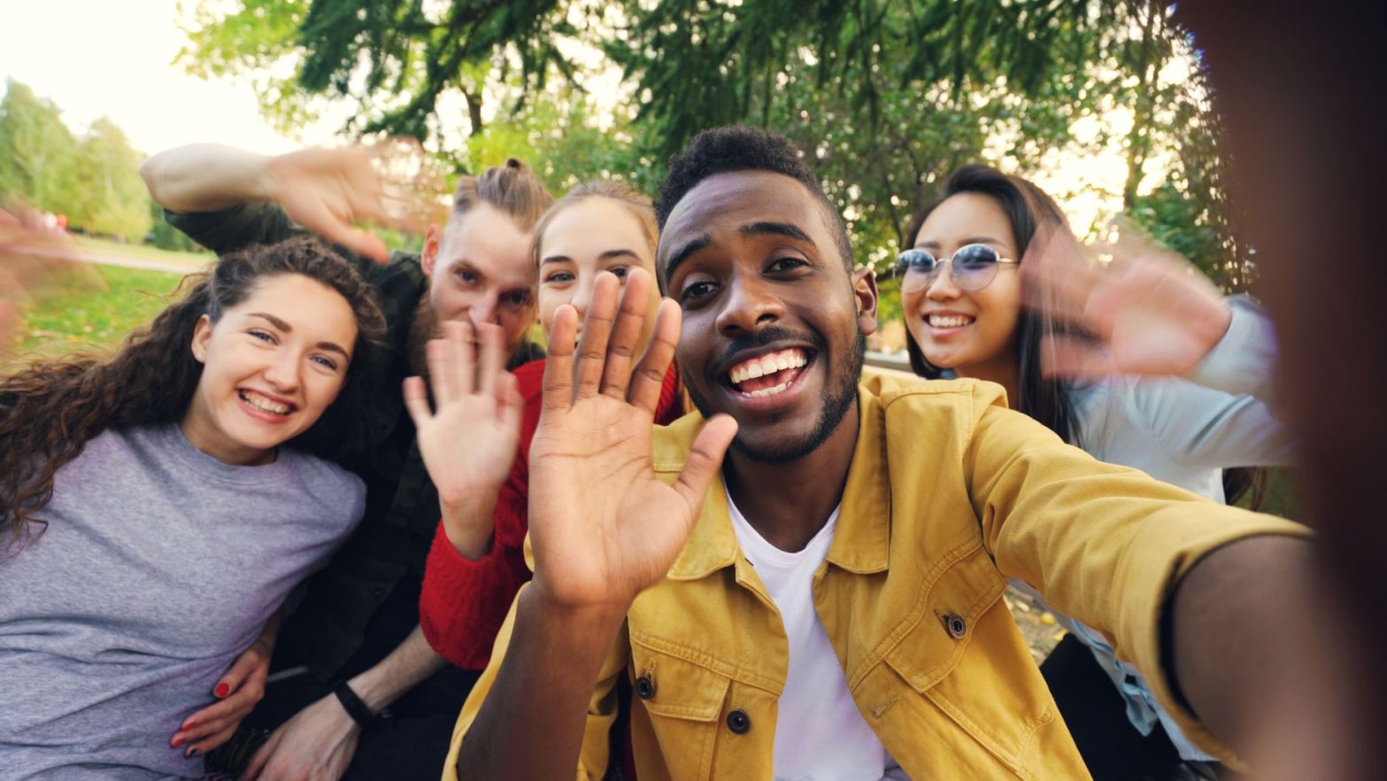 joyful group of friends taking a selfie outdoors